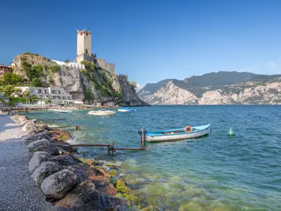Malcesine - The beach of Lago di Garda lake with the town and castle in the background.