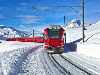 A red swiss train running through the snow, Switzerland