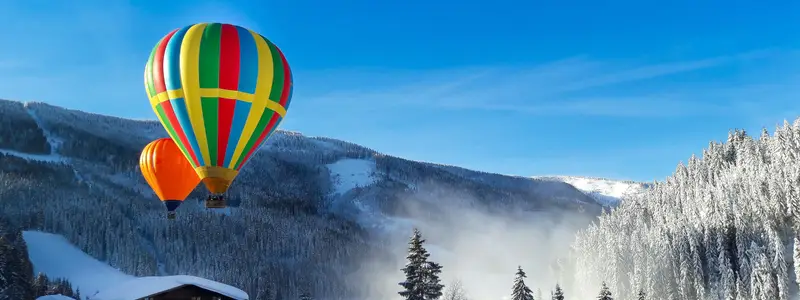 Start der bunten Heissluftballone aus einem nebeligen Tal bei Filzmoos in Salzburg