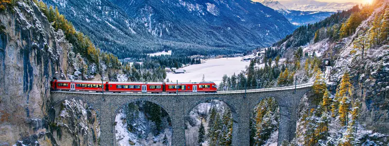 Aerial view of Train passing through famous mountain in Filisur, Switzerland. Landwasser Viaduct world heritage with train express in Swiss Alps snow winter scenery.