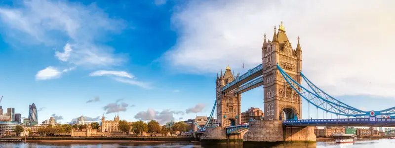 Panoramic London skyline with iconic symbol, the Tower Bridge and Her Majesty's Royal Palace and Fortress, known as the Tower of London as viewed from South Bank of the River Thames in the morning light
