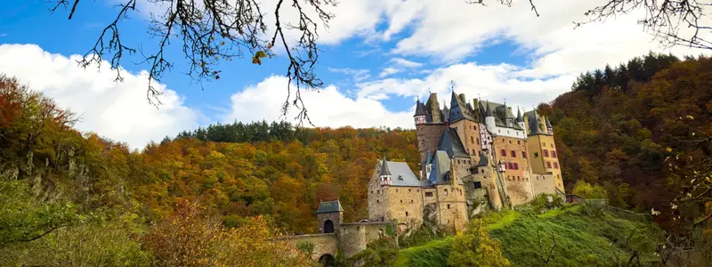 Autumn trees scene with Eltz Castle or Burg Eltz. Medieval castle on the hills above the Moselle River. Rhineland-Palatinate Germany.