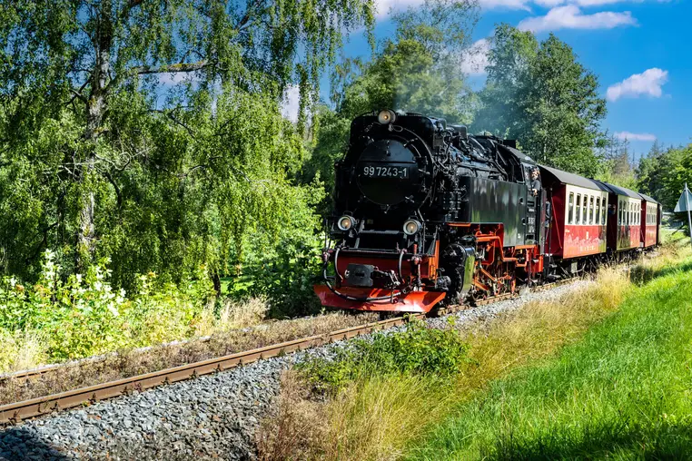 Dampfzug der Harzquerbahn bei Sorge im Harz in Sachsen-Anhalt. Schmalspurbahn mit eingleisiger, nicht elektrifizierter Strecke. Blauer Himmel mit weißen Wolken